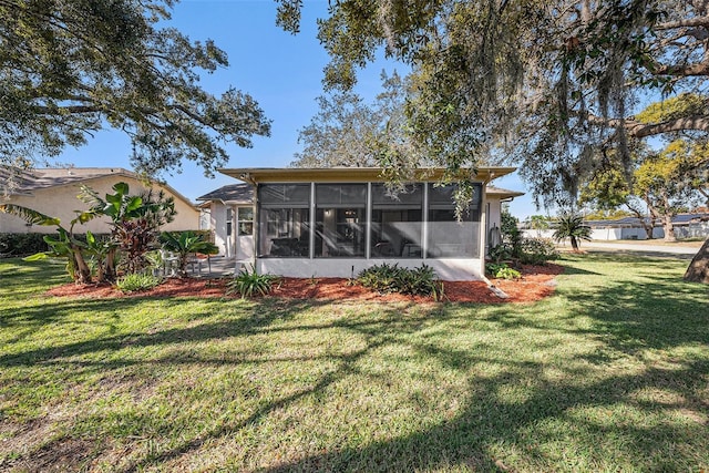 back of house with a sunroom and a yard