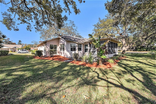 back of property with a lawn and a sunroom