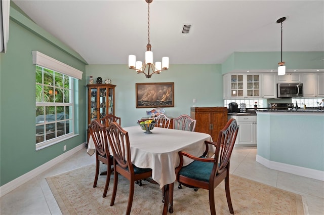 tiled dining room with a notable chandelier