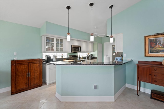 kitchen with sink, kitchen peninsula, appliances with stainless steel finishes, decorative light fixtures, and white cabinetry