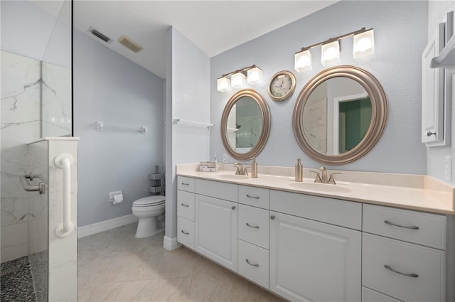 bathroom with vanity, toilet, and a tile shower