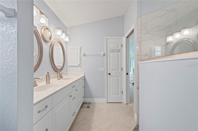 bathroom with tile patterned flooring, vanity, and lofted ceiling