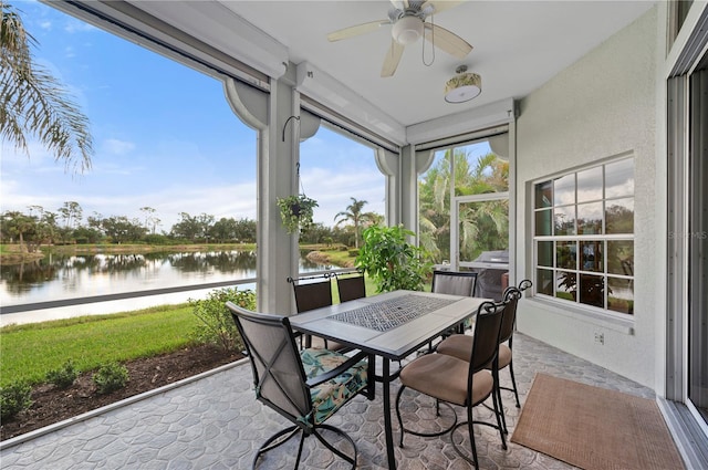 sunroom / solarium with ceiling fan and a water view