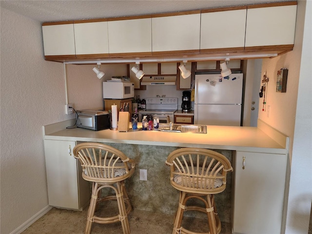 kitchen featuring white cabinetry and white appliances