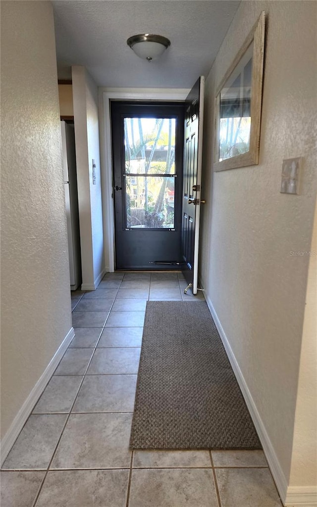 doorway to outside featuring light tile patterned flooring