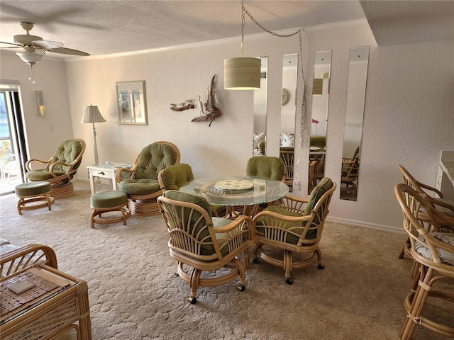 carpeted dining area featuring crown molding, ceiling fan, and a textured ceiling