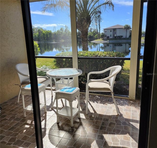 sunroom / solarium with a healthy amount of sunlight and a water view