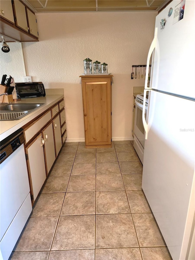 kitchen with sink, white appliances, and light tile patterned floors