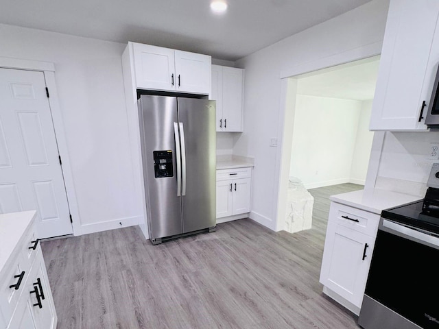 kitchen with white cabinets, light hardwood / wood-style floors, and appliances with stainless steel finishes