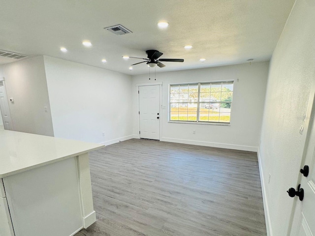 unfurnished living room with hardwood / wood-style flooring and ceiling fan