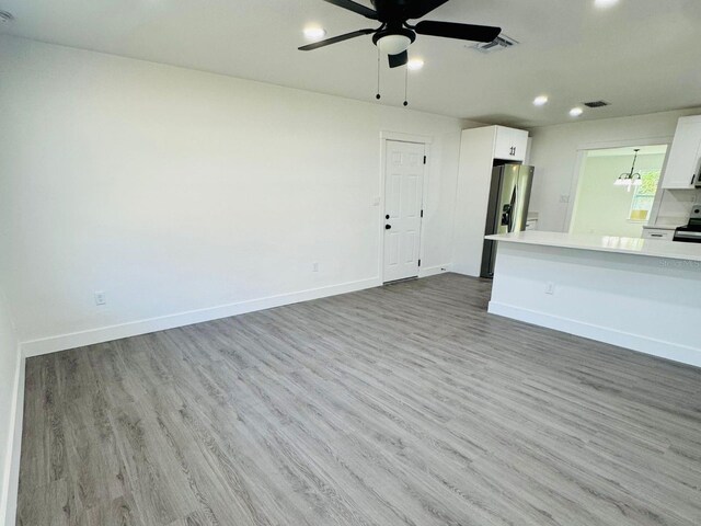 unfurnished living room featuring light wood-type flooring and ceiling fan