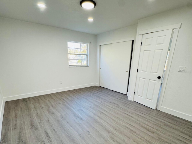 unfurnished bedroom with hardwood / wood-style floors and multiple closets