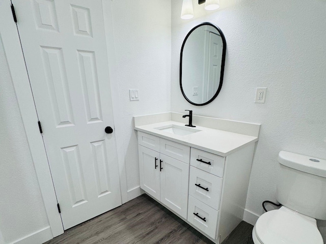 bathroom featuring hardwood / wood-style floors, vanity, and toilet