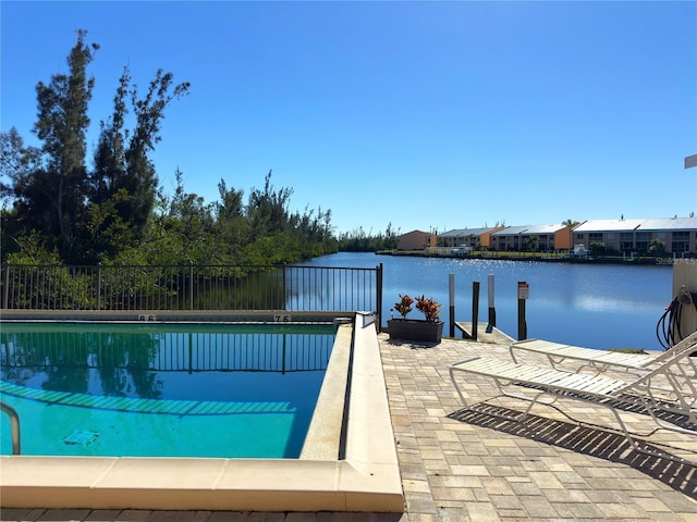 view of pool with a water view, a patio area, and fence