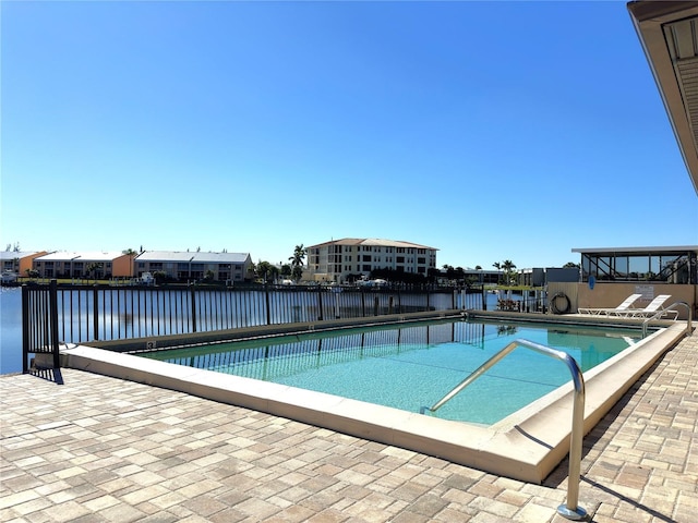 view of swimming pool with a patio and a water view