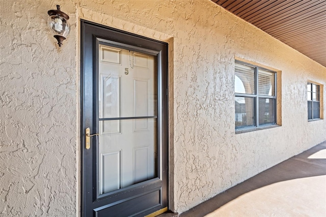 entrance to property featuring stucco siding