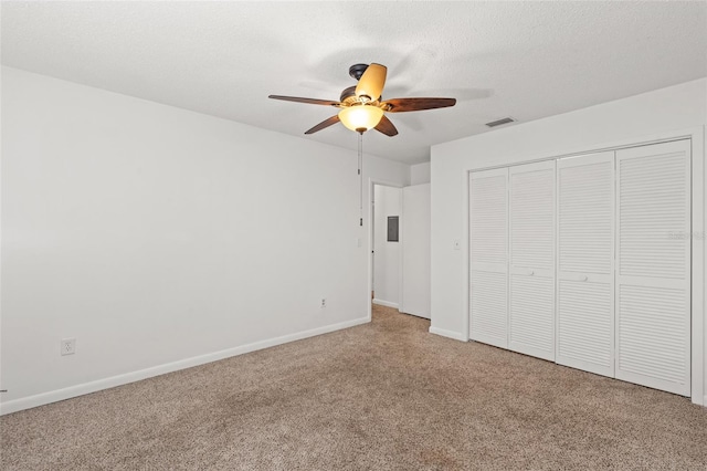 unfurnished bedroom with baseboards, visible vents, a textured ceiling, carpet flooring, and a closet