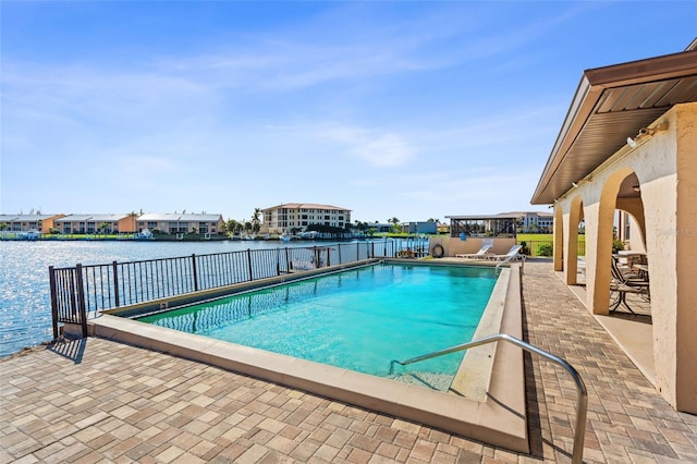 view of pool featuring a patio and a water view