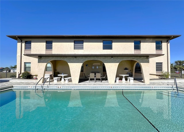 pool with a patio and fence