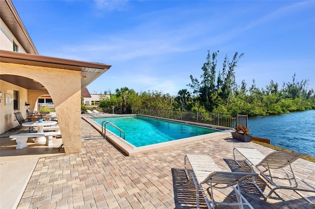 pool featuring a patio area and a water view