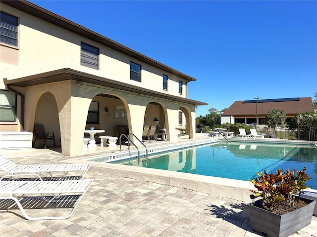 pool featuring fence and a patio