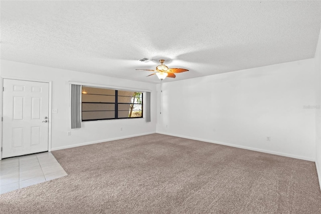 spare room with carpet flooring, ceiling fan, visible vents, and a textured ceiling