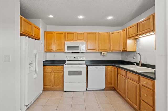 kitchen with white appliances, a textured ceiling, light tile patterned floors, and sink