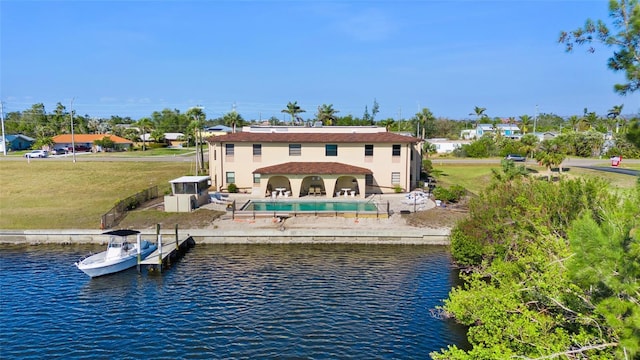 rear view of property featuring a yard, a patio, and a water view