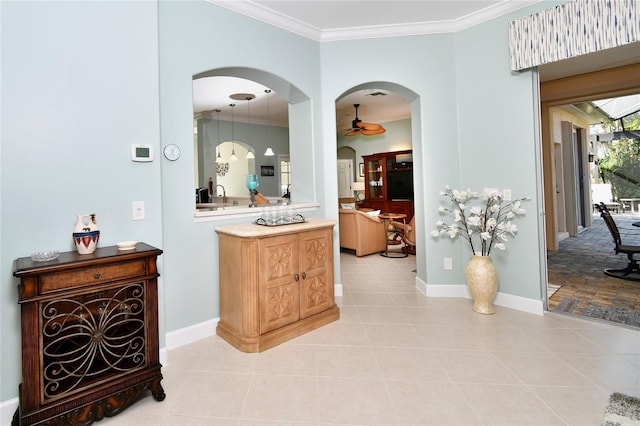 corridor with light tile patterned flooring, sink, and crown molding