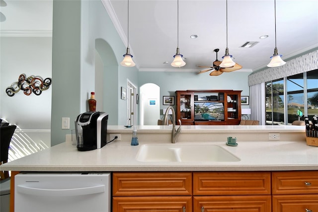 kitchen with white dishwasher, pendant lighting, crown molding, and sink