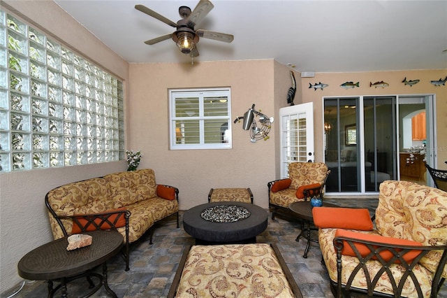 view of patio with ceiling fan and an outdoor living space with a fire pit