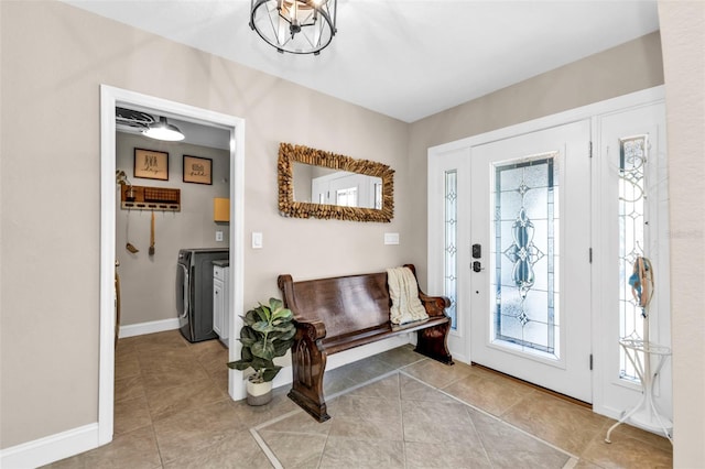 foyer entrance featuring a wealth of natural light, separate washer and dryer, and light tile patterned flooring