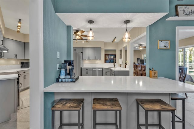 kitchen featuring light tile patterned floors, appliances with stainless steel finishes, ceiling fan, and gray cabinets