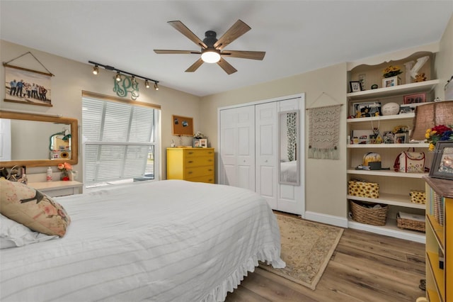 bedroom with baseboards, wood finished floors, a closet, and ceiling fan