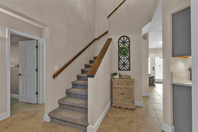 stairs featuring tile patterned flooring and baseboards