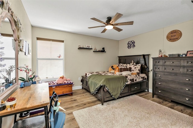 bedroom featuring a ceiling fan, wood finished floors, and baseboards