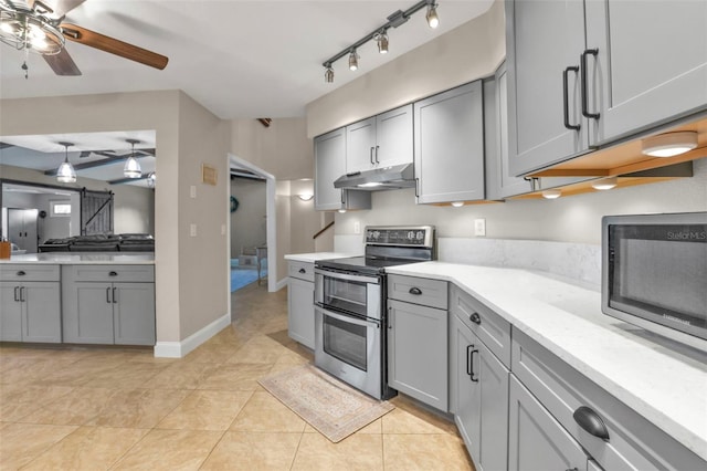 kitchen with a ceiling fan, gray cabinets, light countertops, under cabinet range hood, and appliances with stainless steel finishes