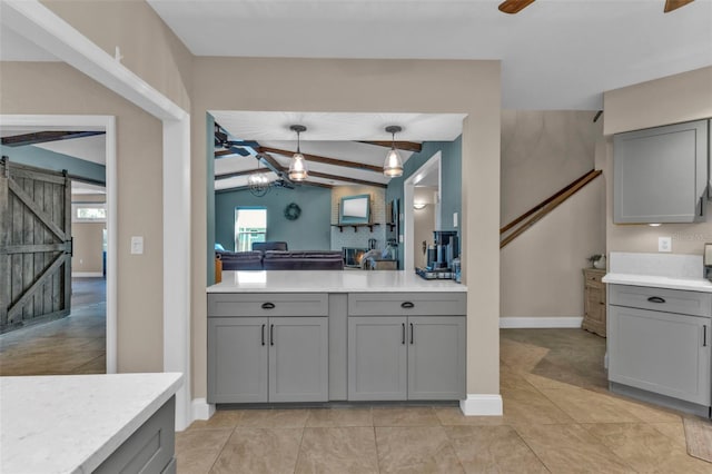 kitchen featuring a barn door, lofted ceiling with beams, light countertops, and gray cabinets