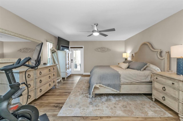 bedroom featuring access to exterior, wood finished floors, baseboards, and ceiling fan