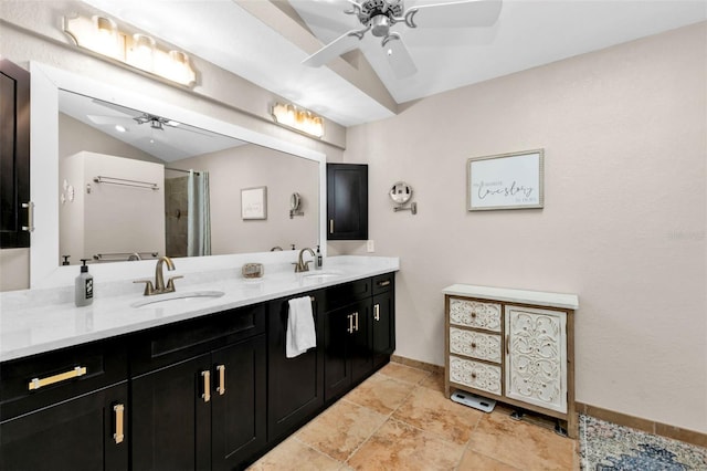 bathroom featuring a sink, double vanity, a ceiling fan, and vaulted ceiling