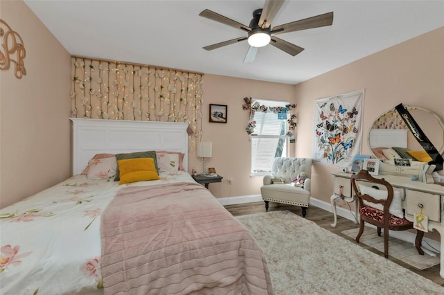 bedroom with baseboards, wood finished floors, and a ceiling fan