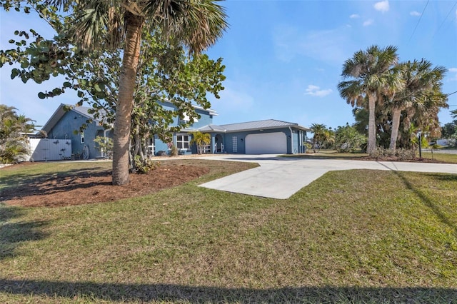 view of front of home with a garage, a front lawn, driveway, and fence