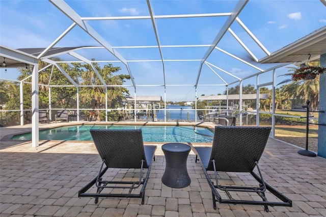 outdoor pool featuring a lanai, a patio, and a water view