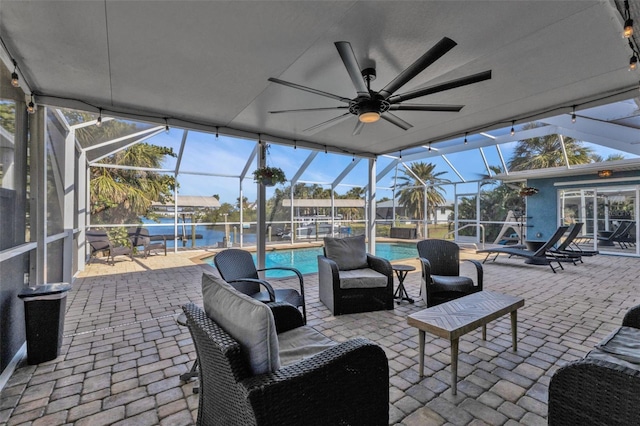 view of patio featuring glass enclosure, an outdoor pool, and ceiling fan