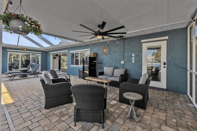 view of patio / terrace with glass enclosure, outdoor lounge area, and a ceiling fan