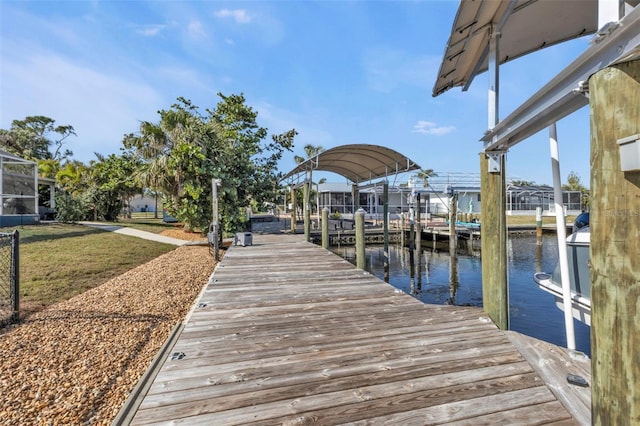 view of dock with a lawn and a water view