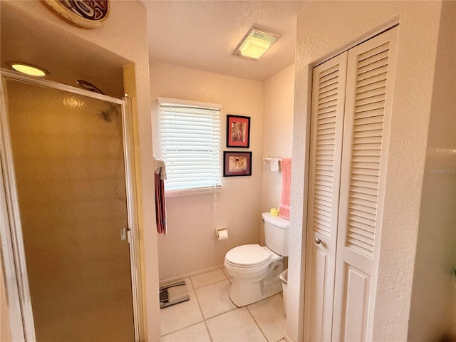 bathroom with a textured ceiling, tile patterned floors, walk in shower, and toilet