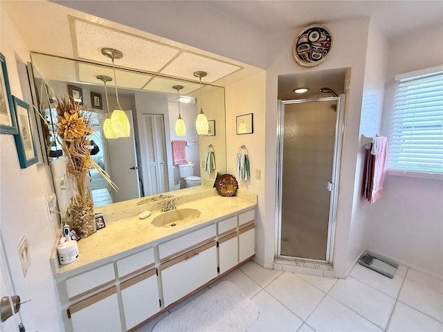 bathroom with toilet, tile patterned flooring, a shower with shower door, and vanity