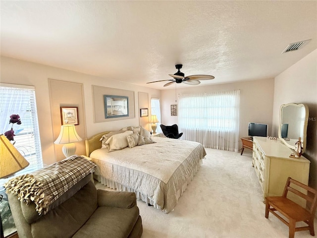 bedroom with ceiling fan and light carpet