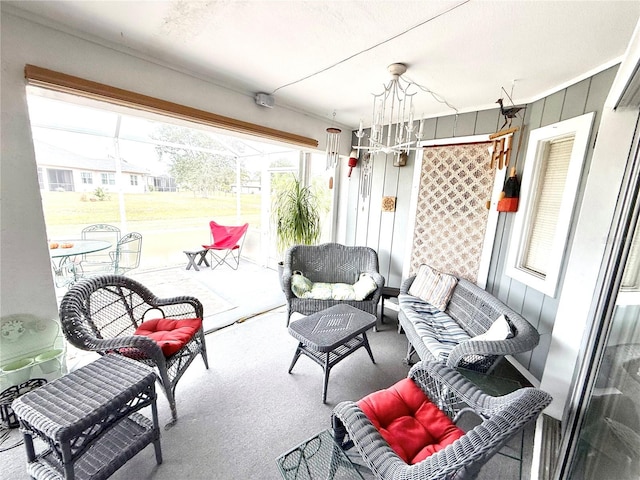 sunroom / solarium featuring a chandelier